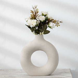 A charming ceramic vase with a biscuit finish, ideal for displaying vibrant flowers with a touch of rustic sophistication.