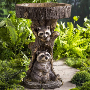 A delightful garden ornament featuring a small raccoon by a bird bath, crafted from resin to add a charming touch to your outdoor decor.