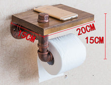 A functional and stylish toilet paper holder featuring industrial pipe design, rustic wooden shelf, and cast iron pipe hardware, perfect for adding a touch of industrial charm to your bathroom decor.