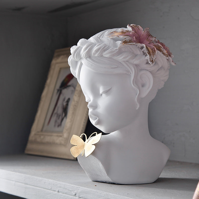 A delicate figurine depicting an angel gently kissing a butterfly, capturing a moment of serenity and beauty.