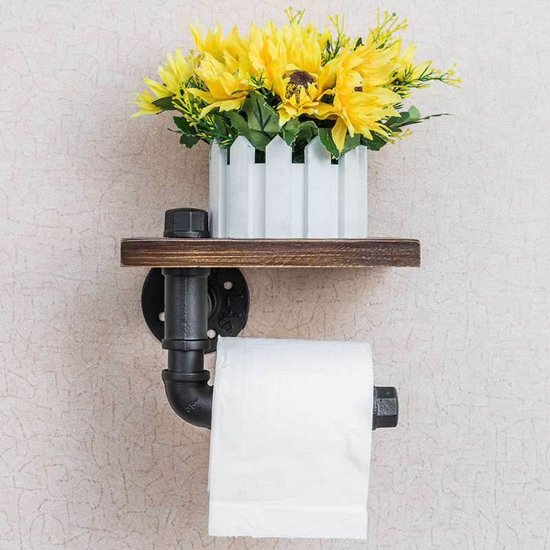 A functional and stylish toilet paper holder featuring industrial pipe design, rustic wooden shelf, and cast iron pipe hardware, perfect for adding a touch of industrial charm to your bathroom decor.