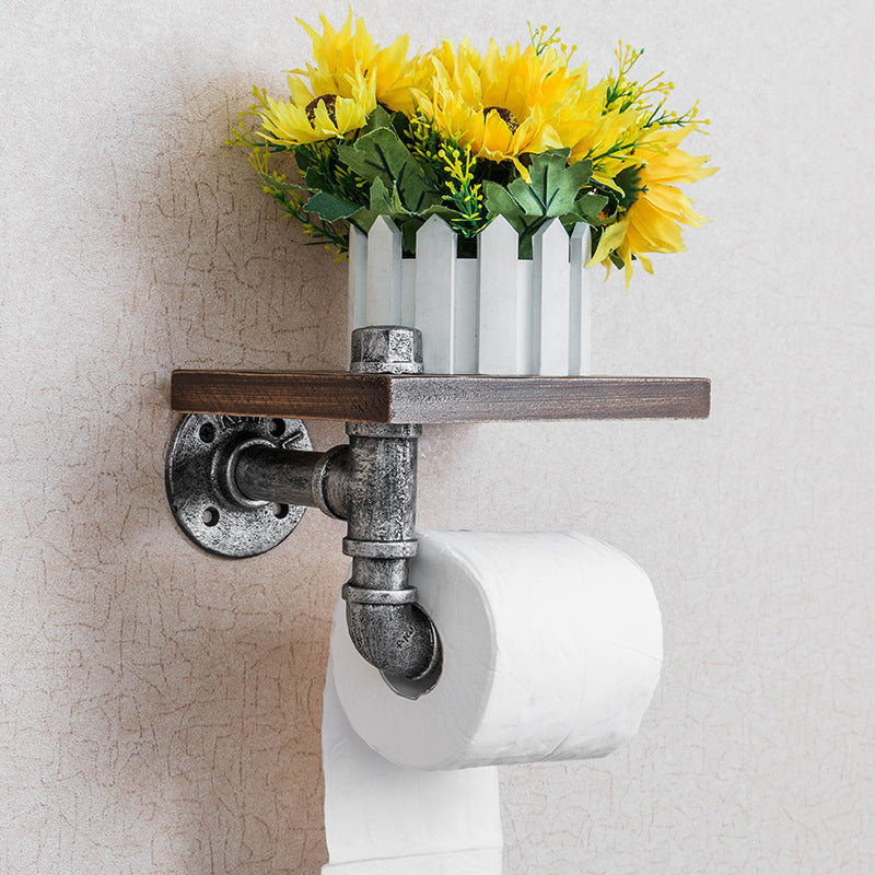 A functional and stylish toilet paper holder featuring industrial pipe design, rustic wooden shelf, and cast iron pipe hardware, perfect for adding a touch of industrial charm to your bathroom decor.